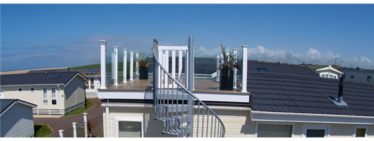 Clear glass frameless panels with white posts and coconut brown decking and spiral staircase