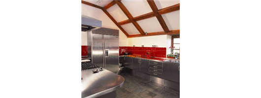 Domestic kitchen with cabinets, worktops, sinks and panelling in stainless steel