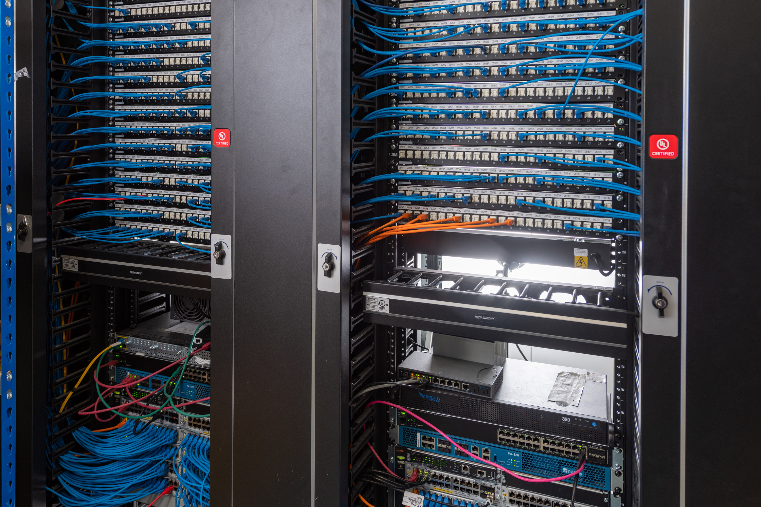 Commercial network cabinet installation with structured data cabling, patch panels, network switches and fibre connections.