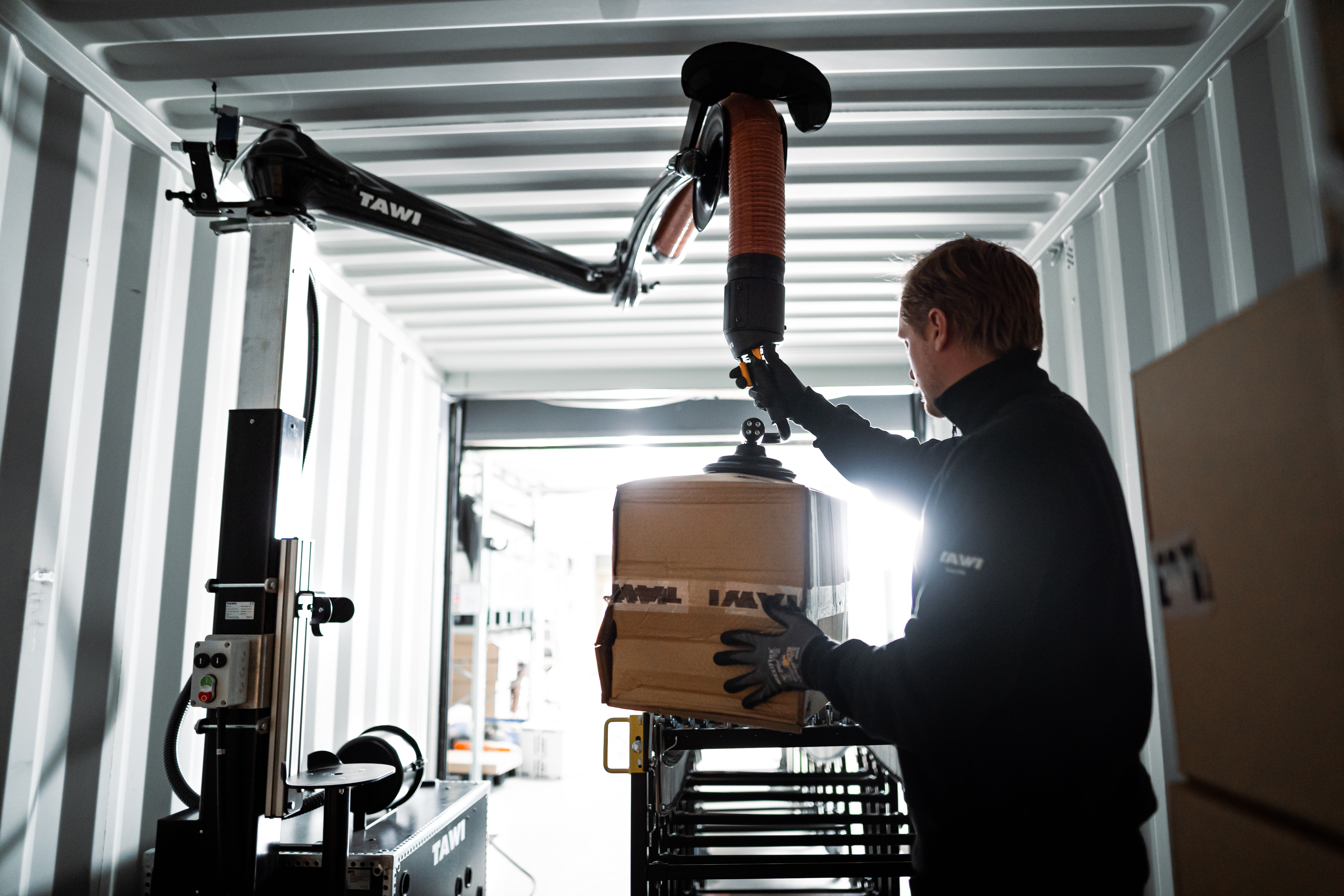 mobile vacuum lifter emptying boxes from a container