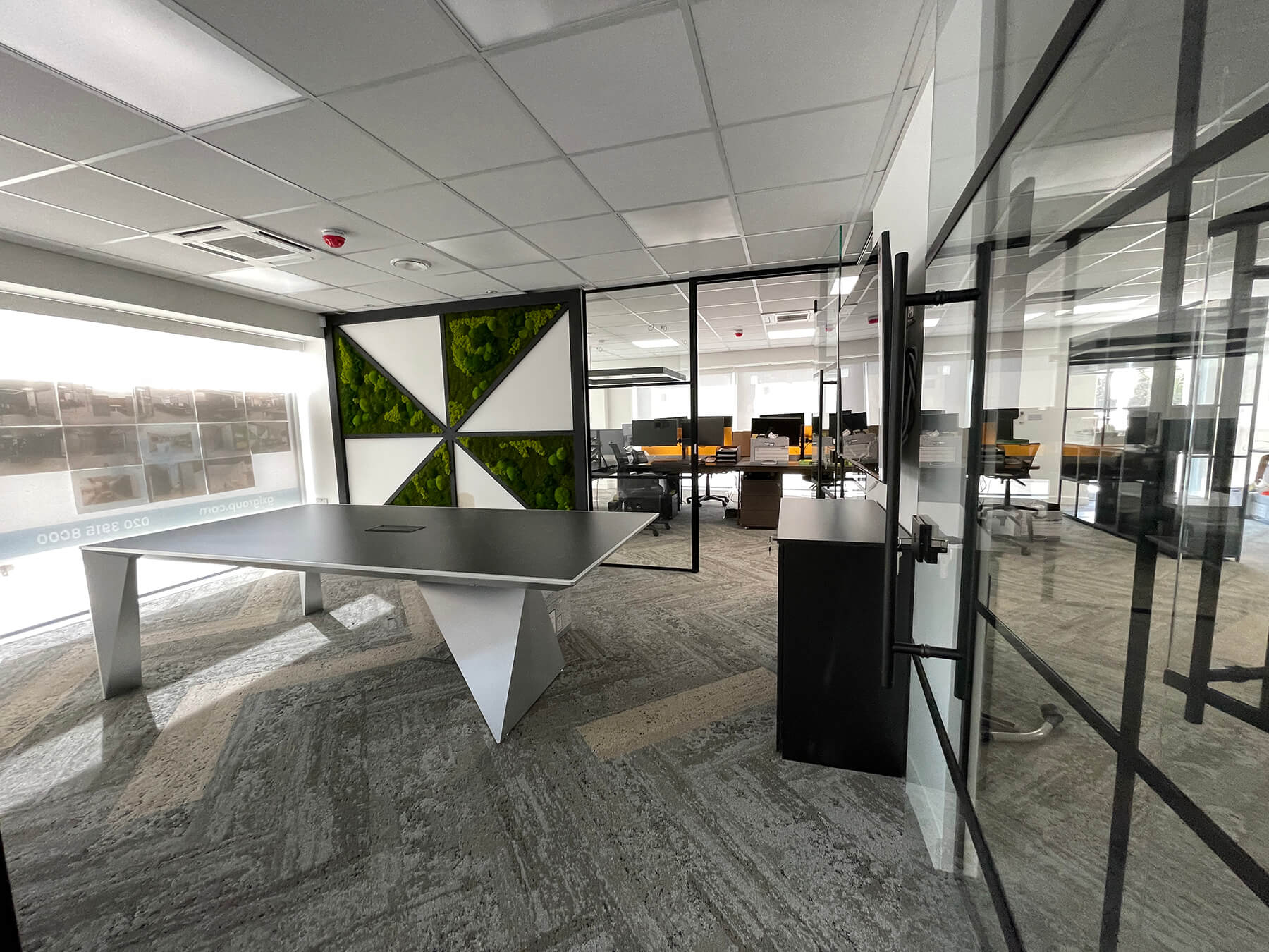 Meeting room and co working space divided with black framed glass partitions